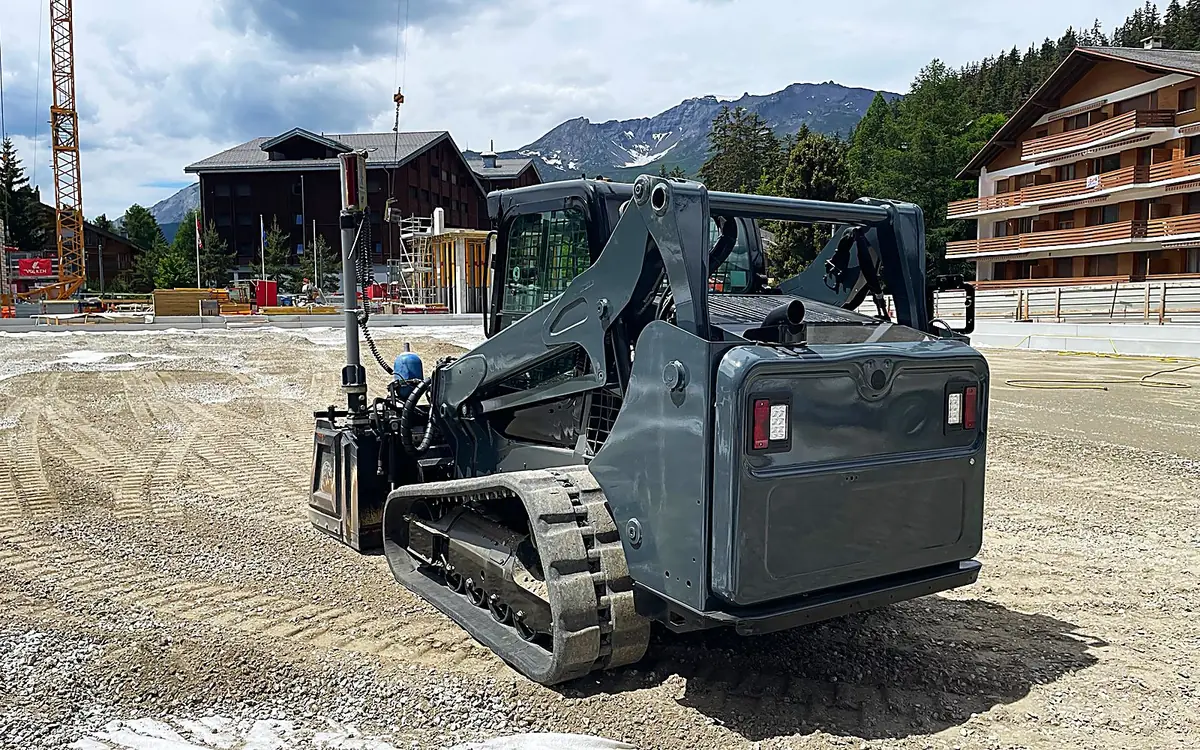 Raupenlader der ProPlanie GmbH auf der Baustelle in Crans-Montana vor Bergpanorama